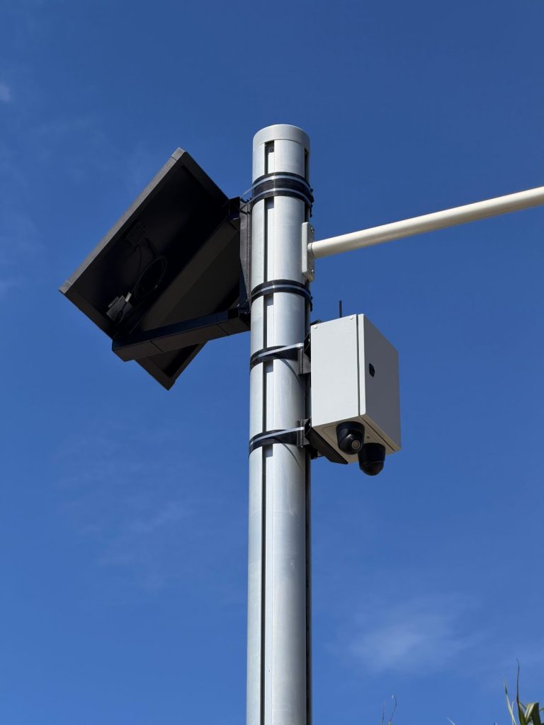 Solar-powered CCTV camera and panel fitted to an existing council street-light pole with custom brackets